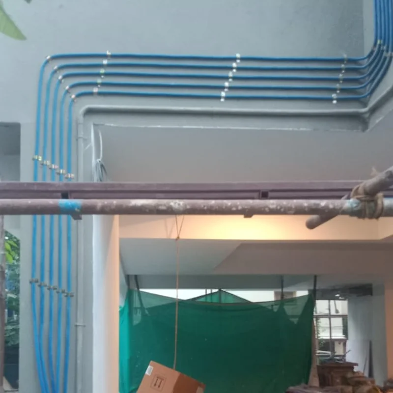 Multiple gas pipeline risers bending along an apartment building under construction