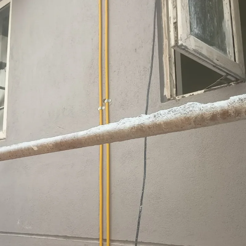 Composite gas pipeline routed along an apartment building exterior wall near a window