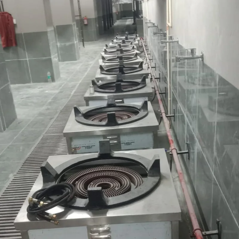 Row of large industrial gas burners connected to a factory gas pipeline