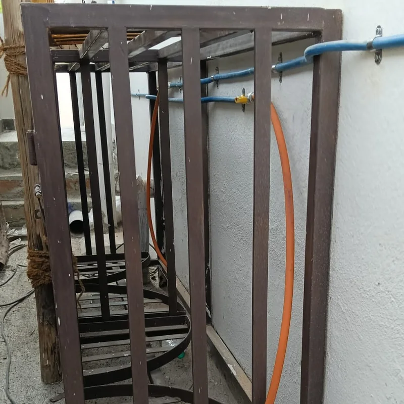 LPG cylinder safety cage installed outdoors with gas pipeline connections