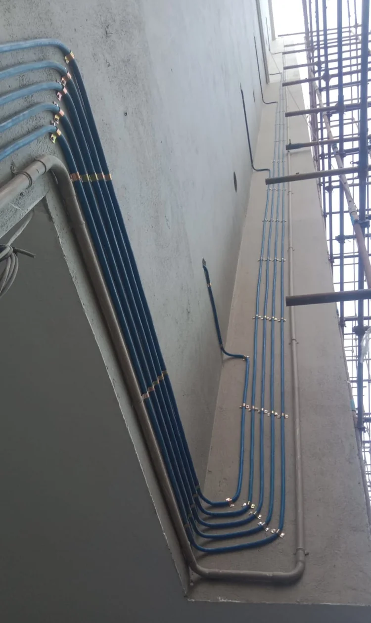 Multiple gas pipeline risers bending along an apartment complex exterior wall